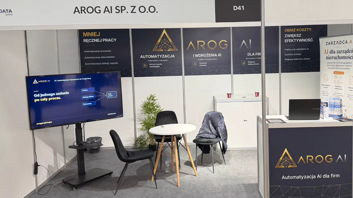 Stoisko AROG AI Sp. z o.o. nr D41 na World of AI & Big Data Expo 2026 w Ptak Warsaw Expo: ekran z adresem arogai.pl/expo, stolik do rozmów i lada z logo AROG AI